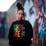 Black sweatshirt with colorful “SHE IS ME” affirmation design celebrating self-love and identity